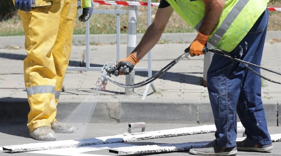 Best Contractor for Parking Lot Striping | Workers paint parking lot stripes on new asphalt.  B
